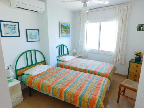 罗萨斯GMID IMMO Apartamento Oasis Atico的一间卧室设有两张床和窗户。