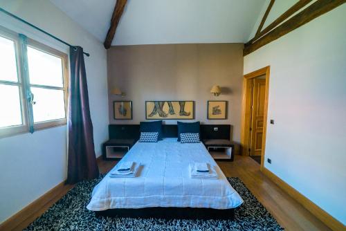塞纳河畔伊夫里Villa Raspail的一间卧室配有一张带蓝色床单的床和一扇窗户。