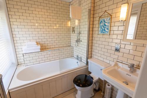 韦茅斯司马格乐旅馆的白色的浴室设有浴缸和水槽。