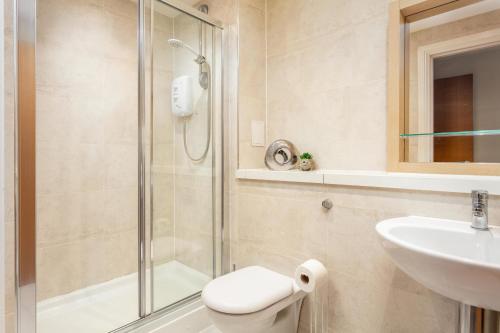 普雷斯蒂克Old Prestwick View - Donnini Apartments的带淋浴、卫生间和盥洗盆的浴室