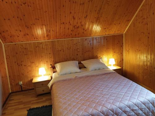 普利特维采湖Apartmani San的卧室配有木墙内的一张床