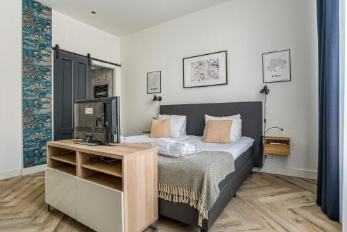 斯海弗宁恩Hosted by Wendy Prins Willem 1的一间卧室配有一张床和一张书桌及电视
