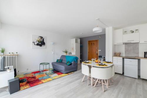 维勒班Nice studio with balcony and parking in Villeurbanne near Lyon - Welkeys的厨房以及带桌子的客厅。