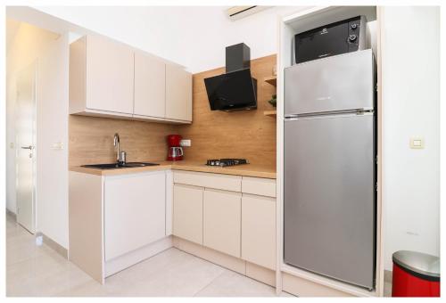 普利莫顿Apartment Jerko 2的厨房配有白色橱柜和冰箱。