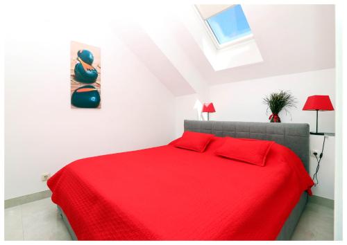 普利莫顿Apartment Jerko 2的一间卧室配有红色的床和红色毯子
