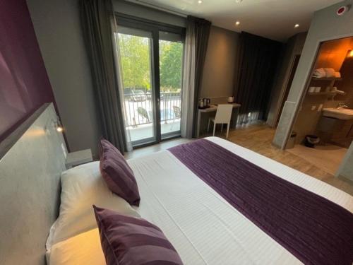 曼特埃尔Hôtel Logis Restaurant La Fontaine的一间带大床的卧室和一个阳台
