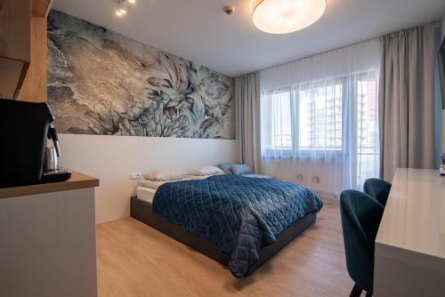 科沃布热格ARKA Apartament Deluxe 503 z widokiem na morze的卧室配有一张床,墙上挂有绘画作品