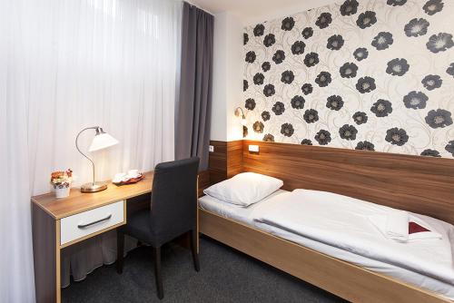 Bučovice阿卡达酒店的酒店客房配有一张床、一张书桌和一张书桌。