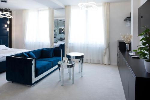 佐洛埃格塞格Z Rooms Boutique的客厅配有蓝色的沙发和2张桌子