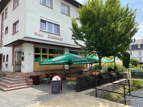 巴特欧波Landgasthof Zum Heidekrug的大楼前带绿伞的餐厅