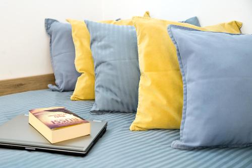 科沙林W&K Apartments - Compact I的一本书坐在床上,上面有枕头