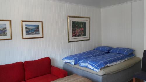 克里斯蒂安桑Apartment Bystranda - City Beach的一间卧室配有一张床和一张红色的沙发