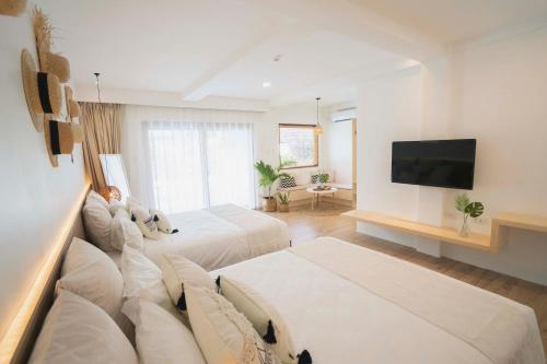 邦劳Ultra Mint Dive Resort的酒店客房设有两张床和一台平面电视。