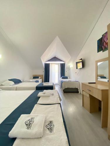 厄吕代尼兹Nefis Hotel Ölüdeniz的客房设有三张床、一个水槽和镜子