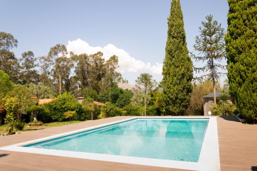 蓬德利马Hotel Rural Solar das Arcadas的一座树木繁茂的庭院内的游泳池