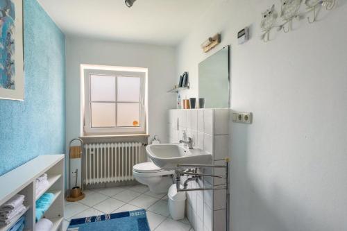 UttingFerienhaus Carin的一间带水槽和卫生间的浴室以及窗户。