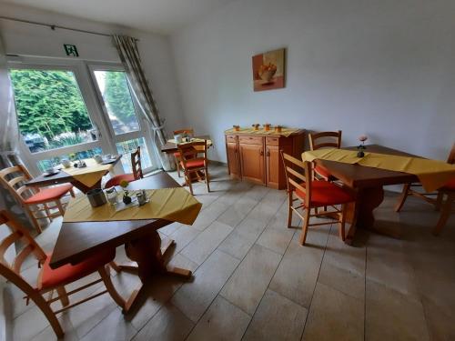 罗德格斯多夫Landpension Rödigsdorf的一间在房间内配有桌椅的餐厅