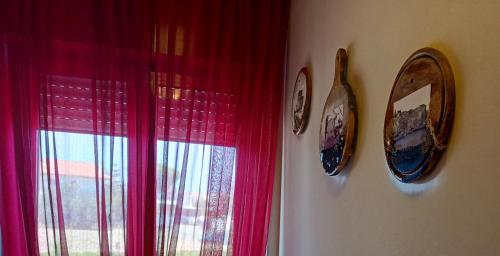 泰尔莫利MSCamere的一间设有两个钟表和红色窗帘的窗户的房间