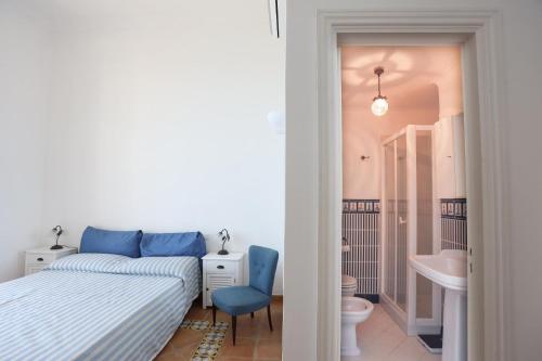 卡普里Casa di charme panoramica a Capri sulla spiaggia.的一间卧室设有一张床、一个卫生间和一个水槽