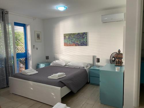 帕图B&B ViaDelMare的一间卧室配有一张带蓝色橱柜和绘画的床。