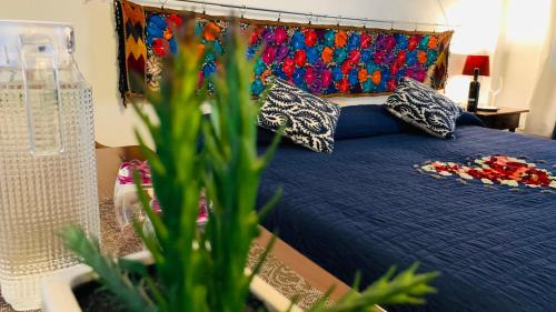 圣胡安特奥蒂瓦坎Villa Las Campanas的一间卧室配有蓝色的床、枕头和植物