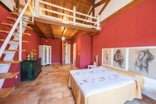 Águeda del CaudilloApartamentos El Capricho的卧室设有红色的墙壁、一张床和梯子