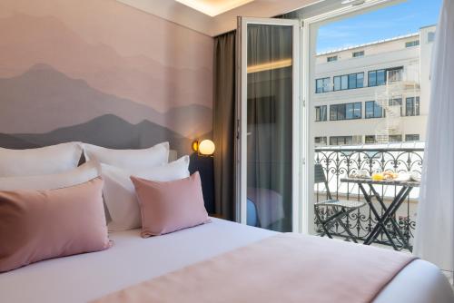巴黎Hôtel Le Milie Rose的一间卧室设有一张床,享有阳台的景色