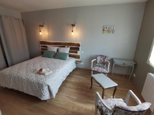 GrazacLes Hauts de Grazac的卧室配有一张床和一张桌子及椅子