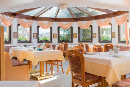 克拉尼斯卡戈拉Garni Hotel Miklič的用餐室设有桌椅和窗户。