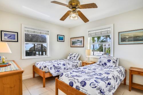 雷顿Beachfront Ocean Duplex的一间卧室配有两张床和吊扇