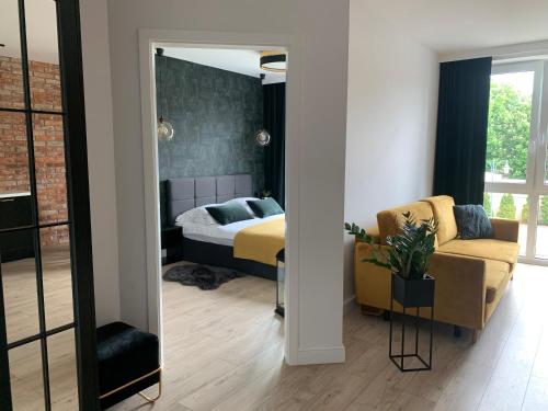 马尔堡Castle Apartments Malbork的一间卧室配有一张床、一张沙发和一面镜子