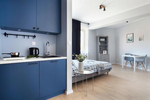 OsiekWOLNE CHWILE的一间厨房,配有蓝色橱柜和一张位于客房内的床