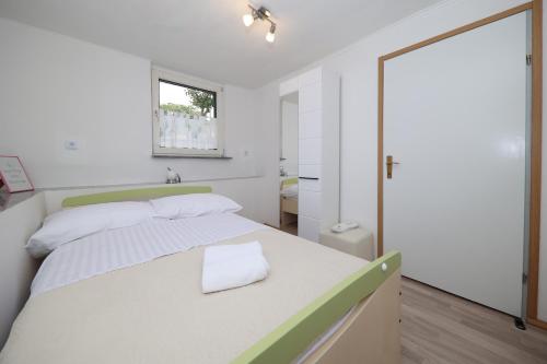 本科瓦茨Country House Korlat的一间卧室配有一张白色大床和绿色床头板