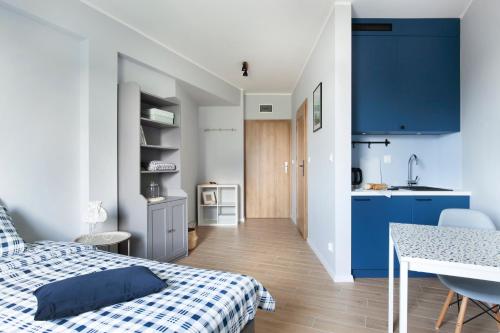 OsiekWOLNE CHWILE的一间带蓝色和白色床的卧室和一间厨房