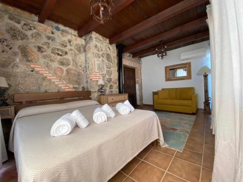 阿雷纳斯德圣佩德罗Casa Rural Olivar de Gredos Entorno privilegiado con vistas de ensueño的一间卧室配有一张带白色毛巾的床