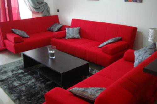 艾西拉Appartement de luxe的客厅里设有一张红色的沙发和一张桌子