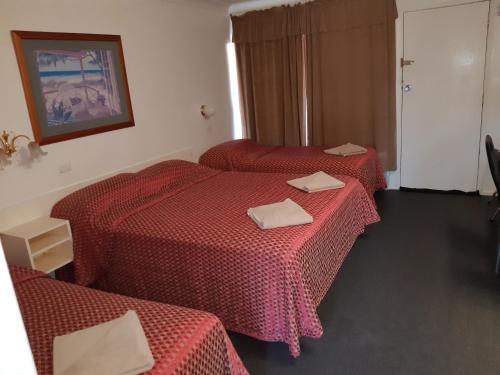 塔姆沃思克鲁尼欧汽车旅馆的两张位于酒店客房的床铺,配有红色床单