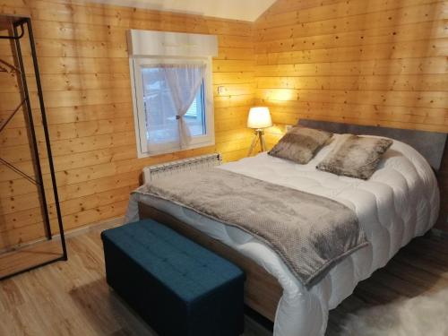 莱托利Le Flocon Vosgien的木制客房的一张床位,设有窗户