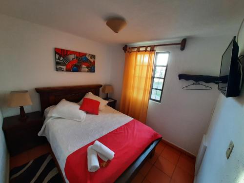 莱瓦镇Aparta Hotel El Refugio de María的一间卧室配有一张床,上面有两条毛巾