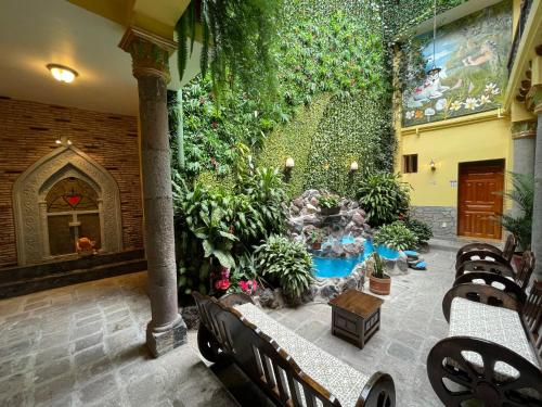 基多Hotel La Basílica Quito的一座带瀑布和植物的室内花园
