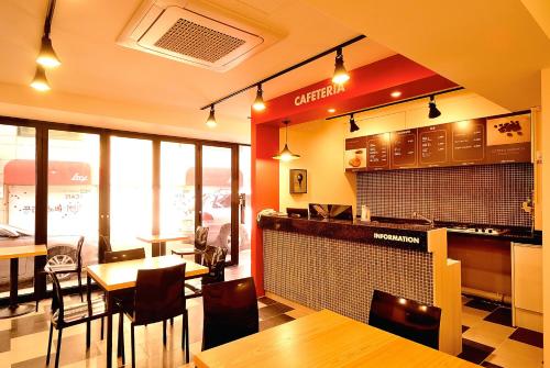 首尔红色旅馆的一间带桌椅的餐厅和一间酒吧