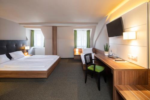 梅明根JOESEPP´S HOTEL am Hallhof的一间卧室配有一张床和一张带电脑的书桌