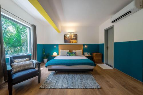 班加罗尔Olive Indiranagar - By Embassy Group的卧室配有床、椅子和窗户。