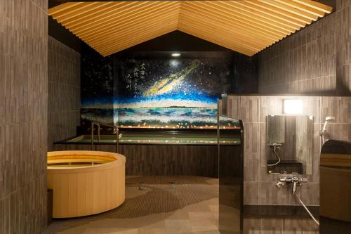 新泻HOTEL GLOBAL VIEW Niigata的浴室内装饰有宇宙的画作