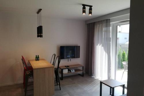 克拉科夫Apartament na Rydlówce的客厅配有电视和桌椅