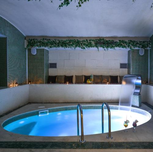 萨拉热窝Heritage Hotel Krone的带壁炉的客房内的热水浴池