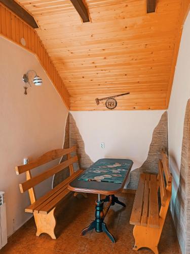 斯拉夫西克Приватна Садиба Потічок的木天花板的客房内的桌子和长凳