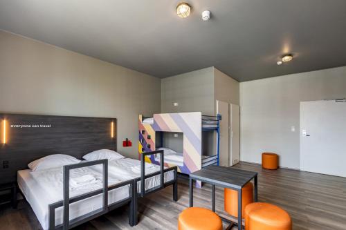 莱比锡莱比锡中央火车站a＆o酒店的卧室配有两张双层床和一张桌子及椅子