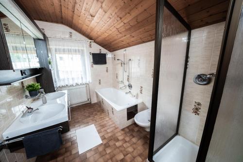卡尔达罗Ferienhaus "La Casa"的带浴缸、盥洗盆和卫生间的浴室