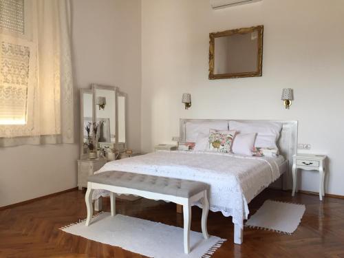 包道乔尼托毛伊Bacchus Apartman - Borbarlang, Badacsony的白色的卧室配有白色的床和镜子